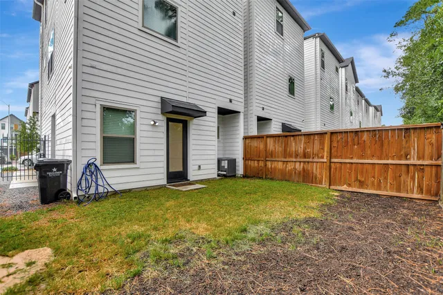 a view of a white house with a large space in front of it