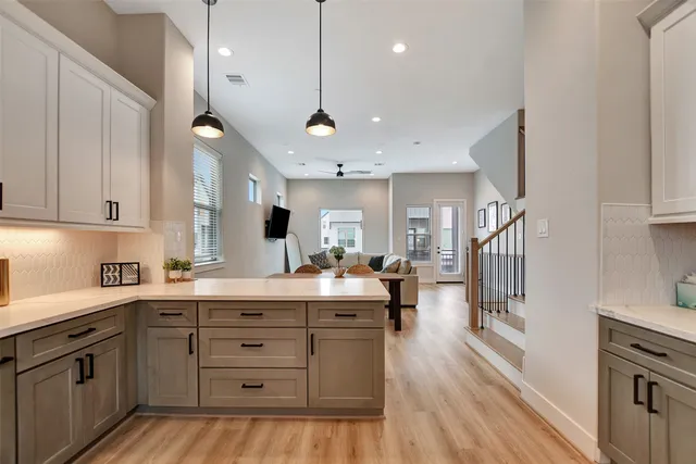 a kitchen with a stove a refrigerator and wooden floor