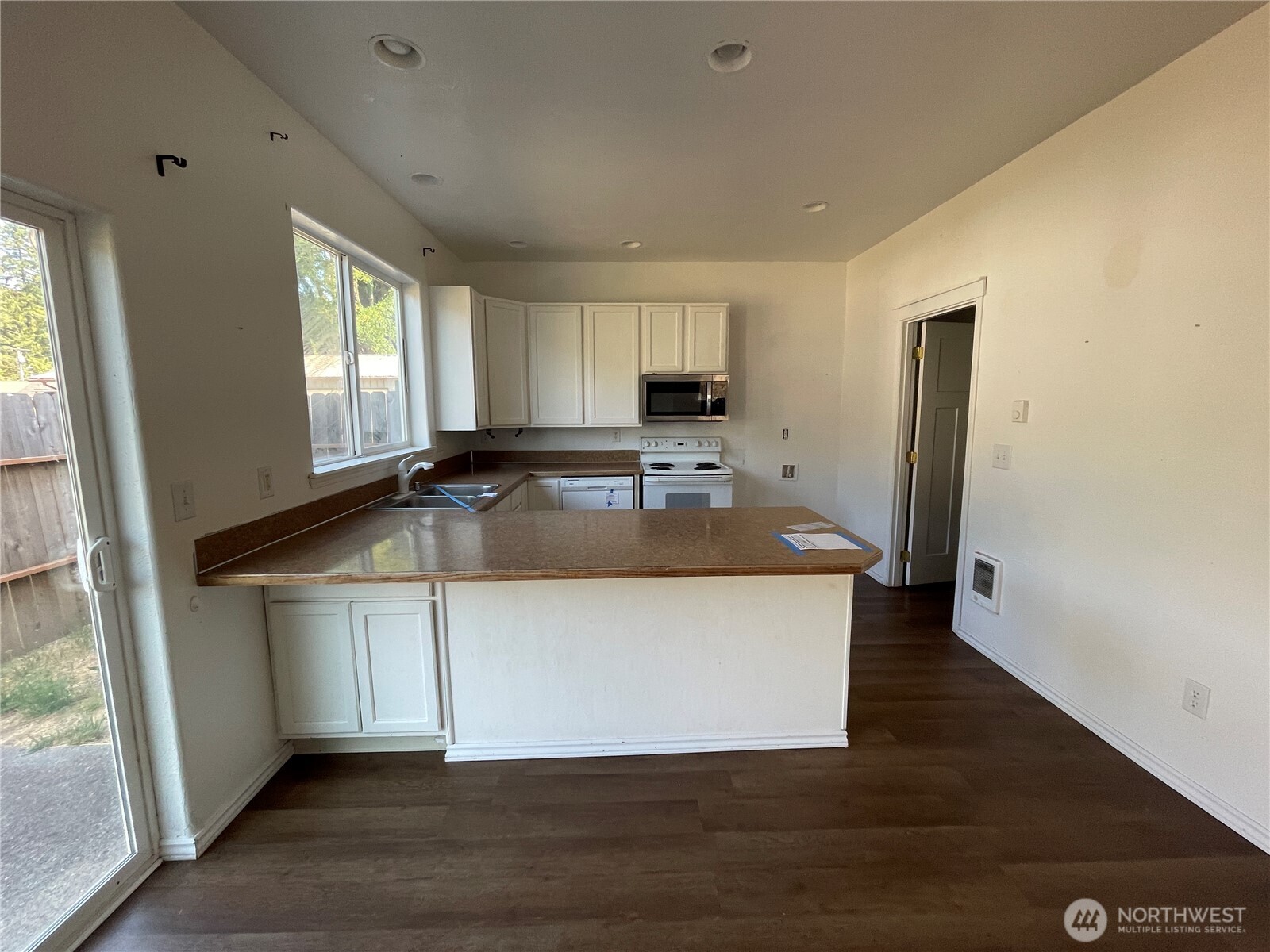 911 West Front Street Winlock, WA 98596 - Photo 6 of 30 a view of a kitchen with kitchen island a sink wooden floor and a large window