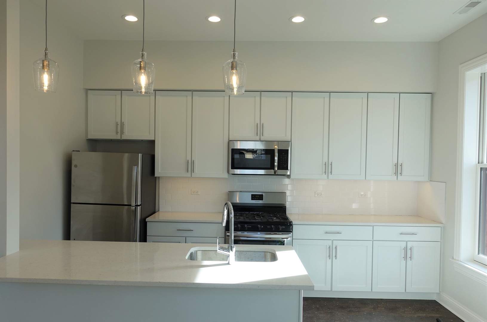 809 North Franklin Street, Unit 3F Chicago, IL 60610 - Photo 5 of 17 a kitchen with kitchen island a sink stainless steel appliances and cabinets