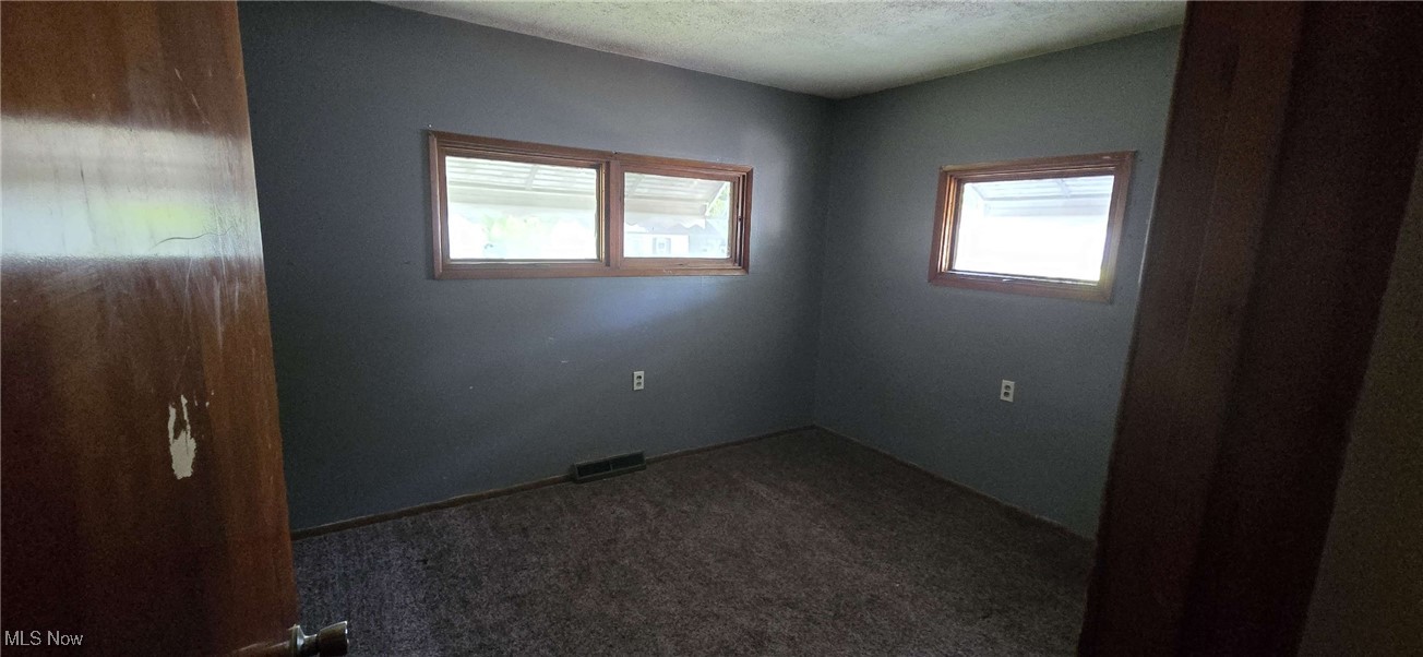 1943 Clyde Road Madison, OH 44057 - Photo 6 of 16 Carpeted empty room featuring a textured ceiling