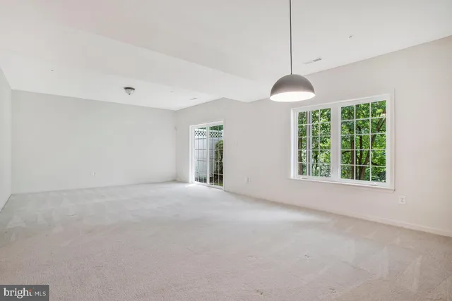 a view of a patio with a table and chairs and couches with wooden fence