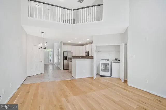 a kitchen with white cabinets and chandelier