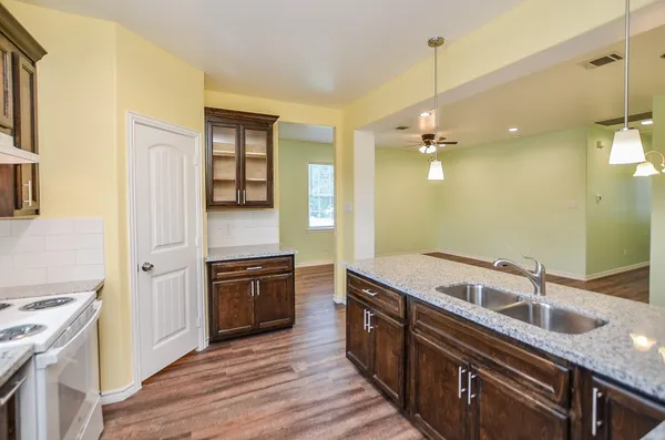 a kitchen with granite countertop a sink and wooden cabinets