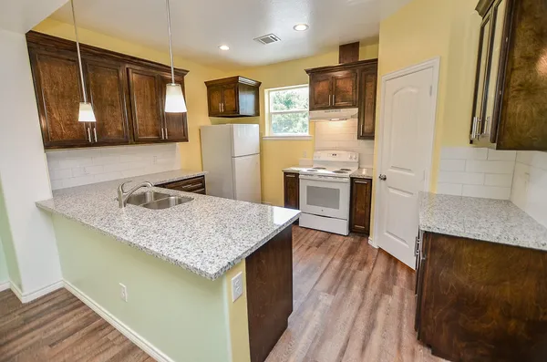 a kitchen with stainless steel appliances granite countertop a sink stove and refrigerator