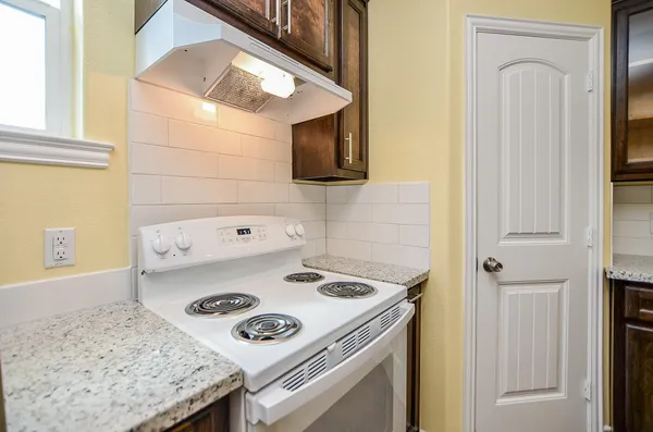 a white stove top oven sitting inside of a kitchen