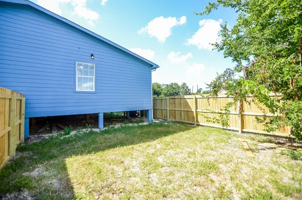 a view of a backyard with brick wall and a large tree