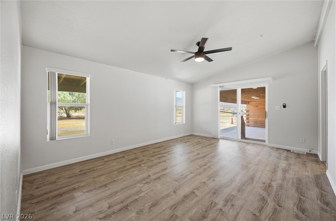 1531 West Harris Farm Road Pahrump, NV 89060 - Photo 25 of 37 Natural light illuminates this spacious living area with durable wood-look flooring and a soaring vaulted ceiling.