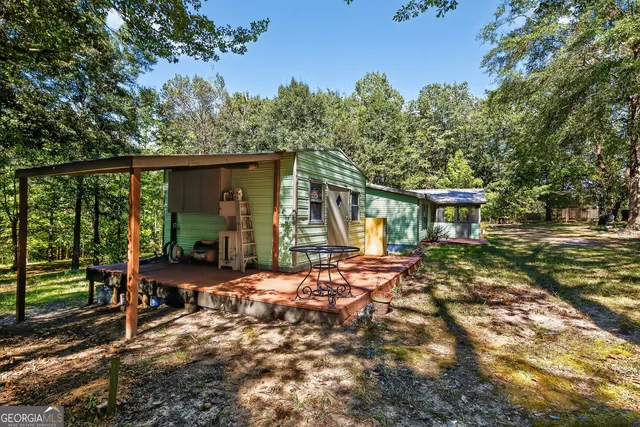 a view of a chair and table in backyard of the house