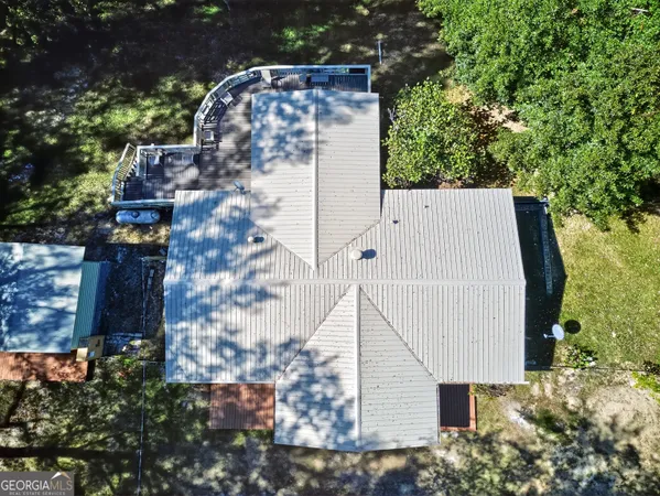 an aerial view of a house with a yard and trees