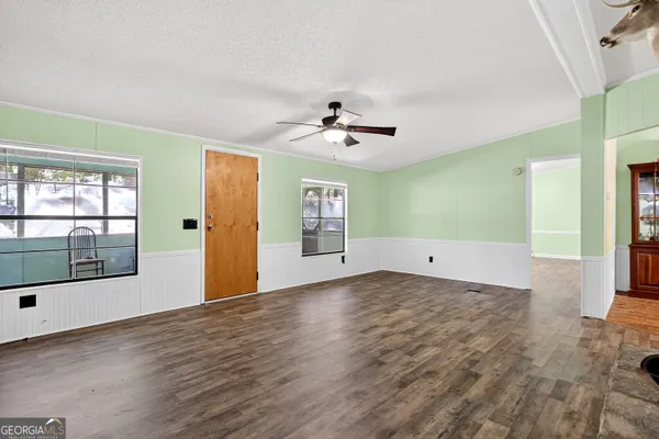 a living room with a bed and ceiling fan