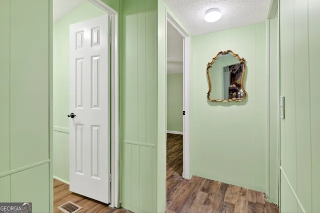 a view of a hallway with wooden floor and closet