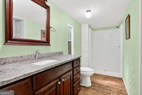 a view of a living room and kitchen with wooden floor