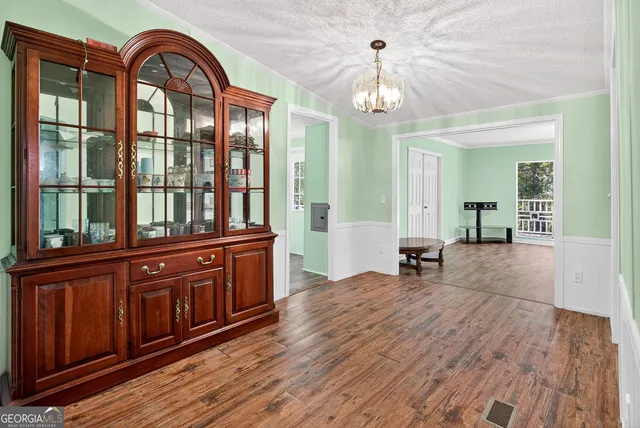 a view of a living room and kitchen with wooden floor