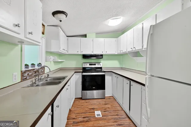 a kitchen with kitchen island granite countertop a sink appliances cabinets and a counter top space