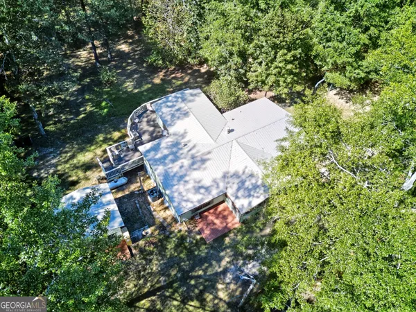 an aerial view of a house with a yard and large trees