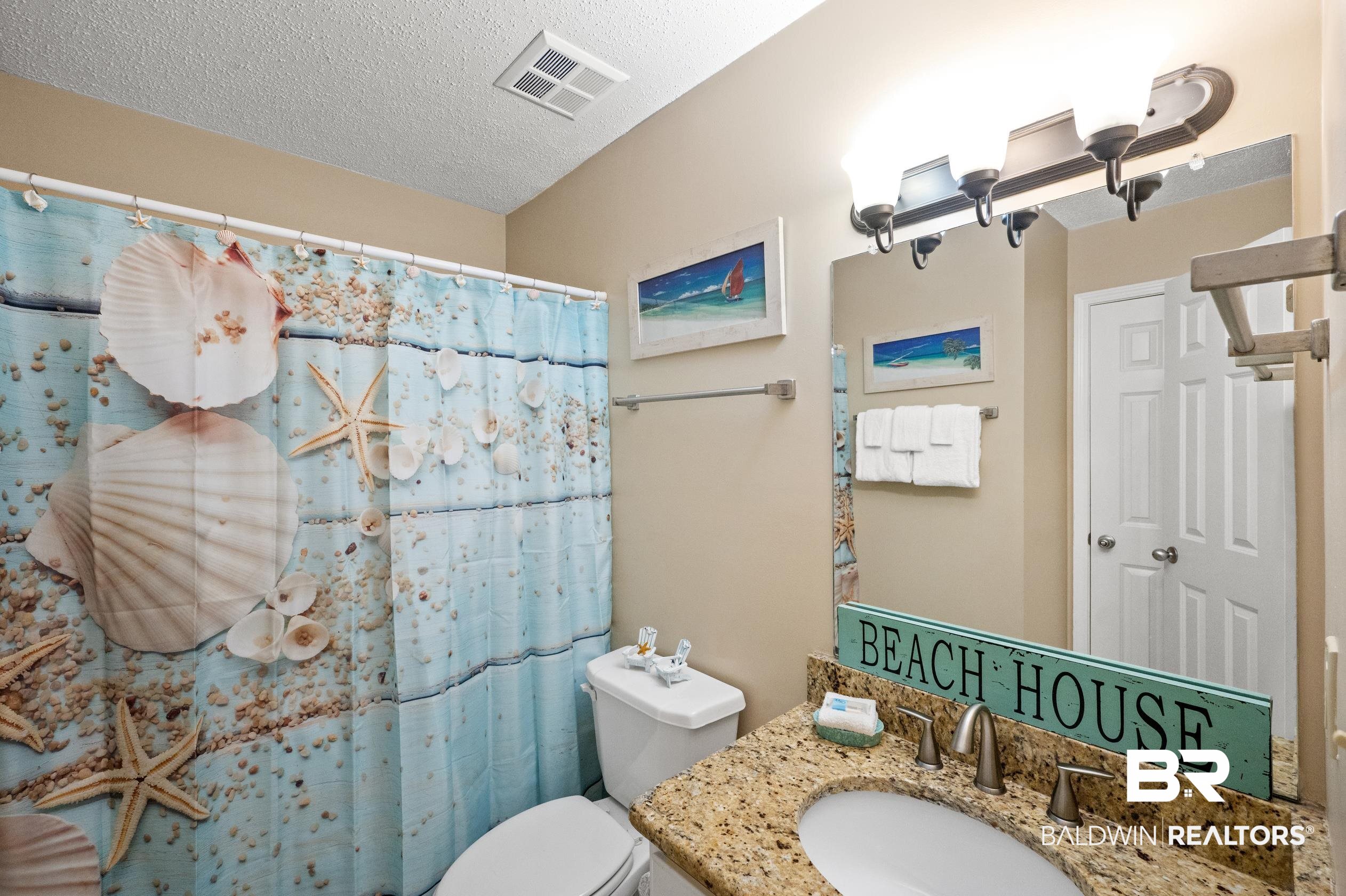 1380 Fort Morgan Road, Unit 106 Gulf Shores, AL 36542 - Photo 10 of 20 Bathroom featuring curtained shower, toilet, visible vents, and a textured ceiling