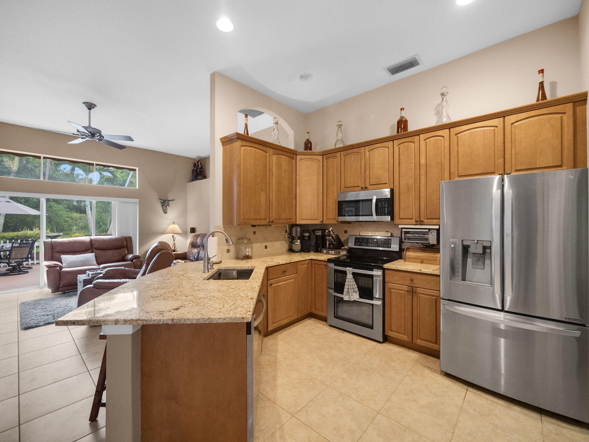 8121 Southwest Yachtsmans Drive Stuart, FL 34997 - Photo 9 of 28 a kitchen with refrigerator a sink and chairs
