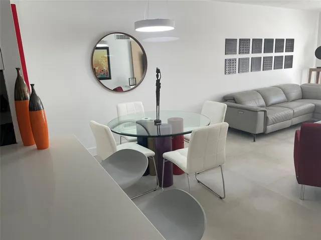 a dining room with furniture and a mirror