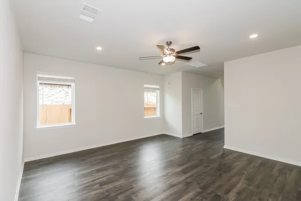 a view of empty room with wooden floor and window