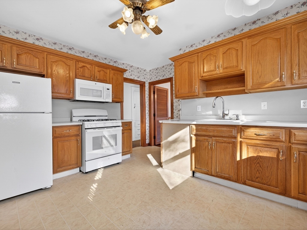 104 Greaton Road Boston, MA 02132 - Photo 29 of 42 a kitchen with stainless steel appliances granite countertop a stove a sink dishwasher and a refrigerator with wooden cabinets