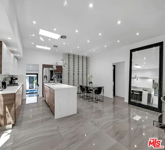 a living room with stainless steel appliances furniture and a kitchen view