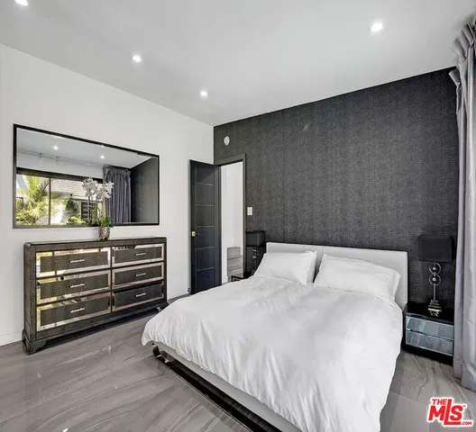 a bedroom with a bed and a flat tv screen