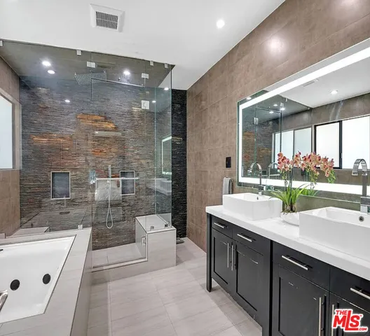 a spacious bathroom with a sink a large mirror and a bathtub