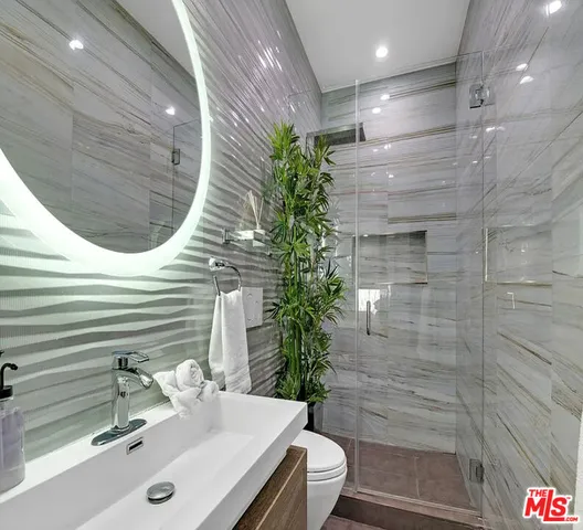 a bathroom with a sink a toilet and shower