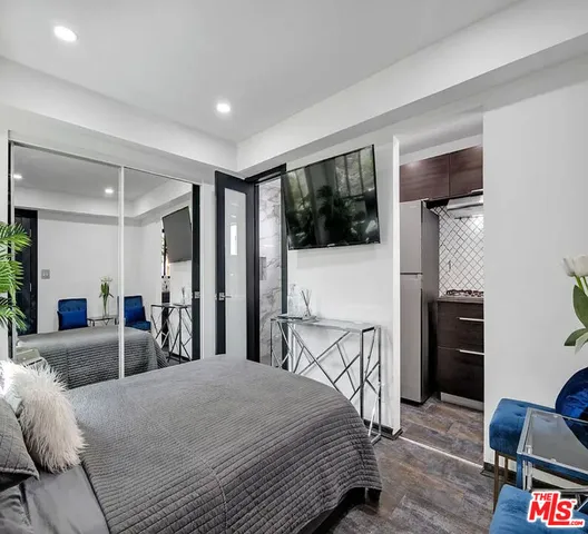 a bedroom with furniture and a flat screen tv