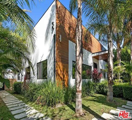 a front view of a multi story residential apartment building with yard and green space