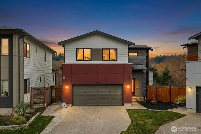 a front view of a house with yard and parking