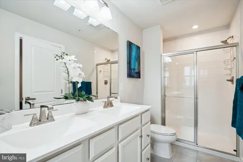 a bathroom with a double vanity sink toilet and shower