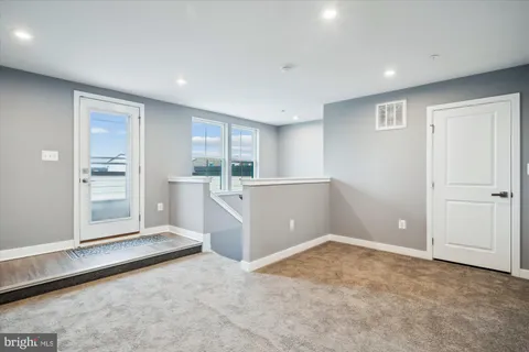 an empty room with cabinet and mirrors