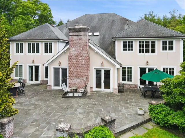 a view of a white house with a yard and sitting area