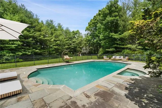 a view of a swimming pool with a yard and sitting area