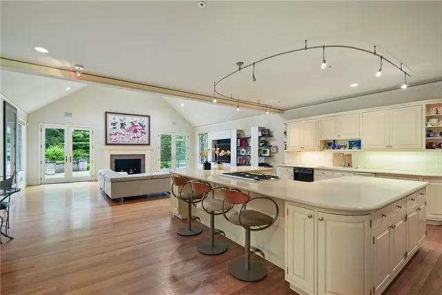 a kitchen with stainless steel appliances granite countertop a sink dishwasher and a stove with wooden floor