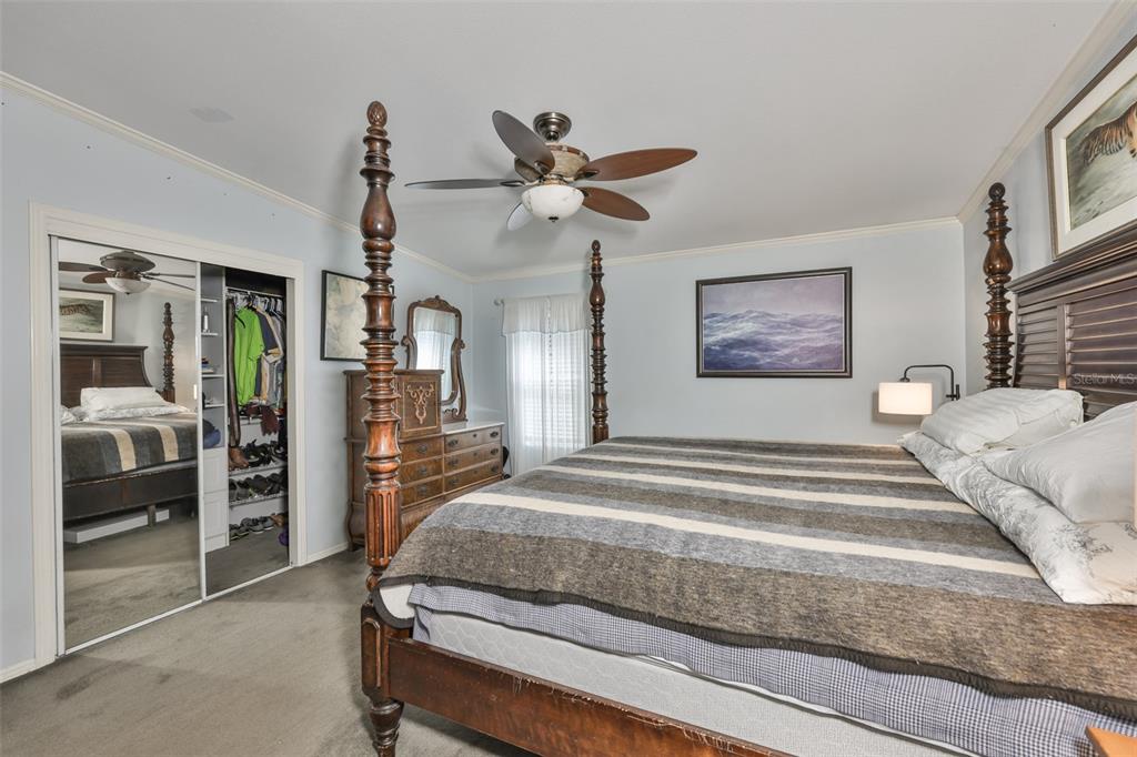 20112 Hobbs Road Wimauma, FL 33598 - Photo 26 of 94 a spacious bedroom with a bed and a chandelier