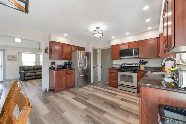 a kitchen with stainless steel appliances kitchen island granite countertop a refrigerator stove and oven