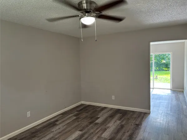 a view of a room with wooden floor and a ceiling fan