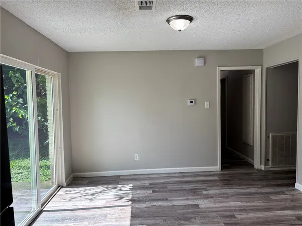 a view of a hallway with wooden floor and entryway