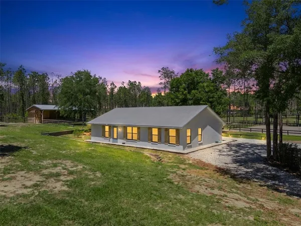 a aerial view of a house with swimming pool next to a big yard