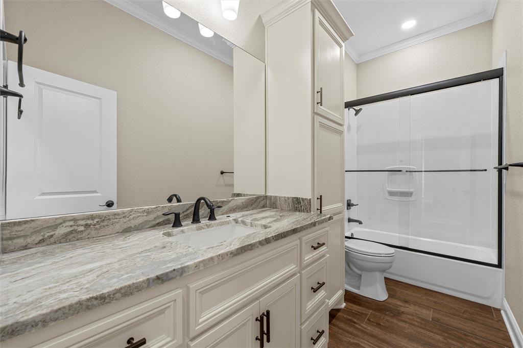 109 Water View Lane Robinson, TX 76706 - Photo 21 of 35 a bathroom with a granite countertop sink a toilet a mirror and shower
