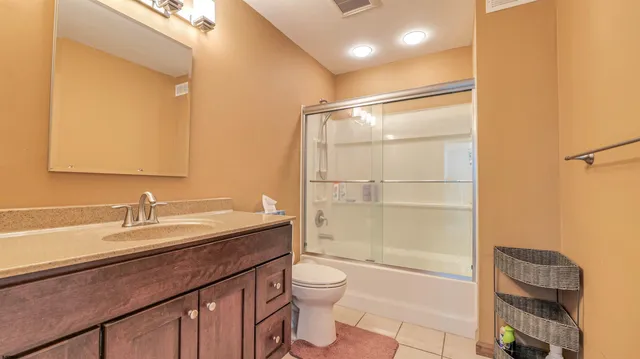 a bathroom with a granite countertop sink toilet mirror and shower