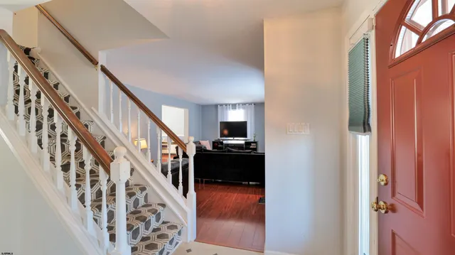 a view of a hallway with wooden floor and staircase