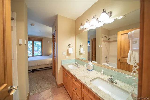 a bathroom with a granite countertop sink a large mirror and a bathtub