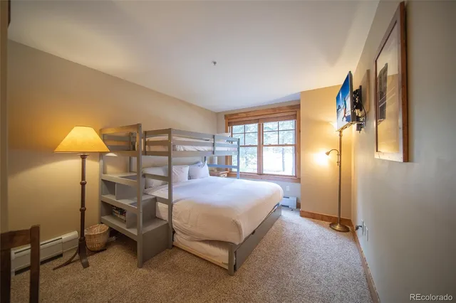 a bedroom with a bed and a painting on the wall