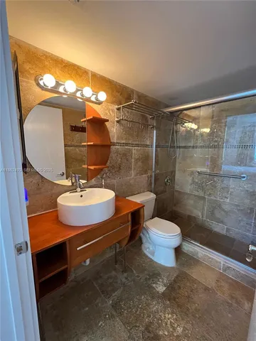 a bathroom with a sink toilet a mirror and shower