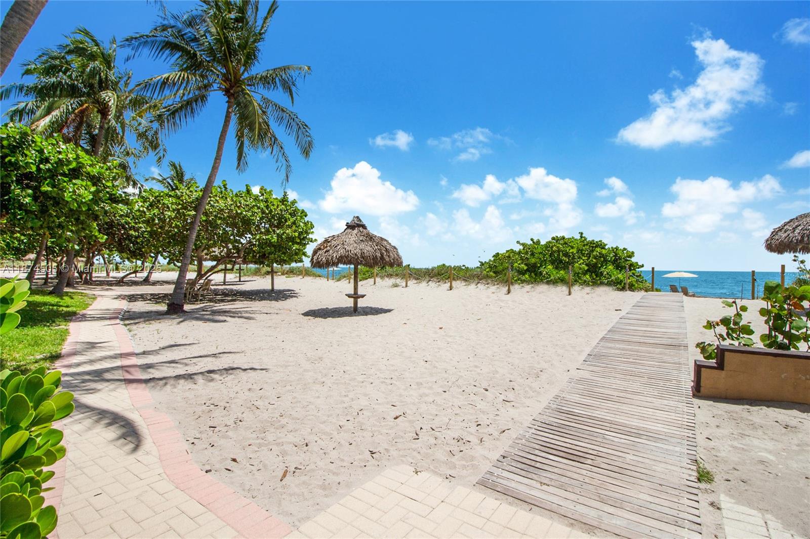 1111 Crandon Boulevard, Unit B606 Key Biscayne, FL 33149 - Photo 20 of 33 a view of a swimming pool with a yard and palm trees