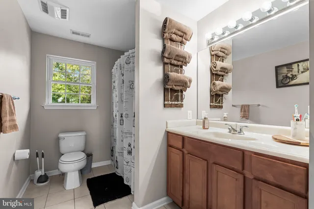 a spacious bathroom with a toilet sink double vanity and shower